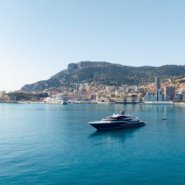 A large yacht is anchored in the harbor of Monaco.