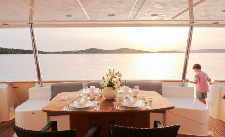 Table set for dinner on a yacht at sunset.
