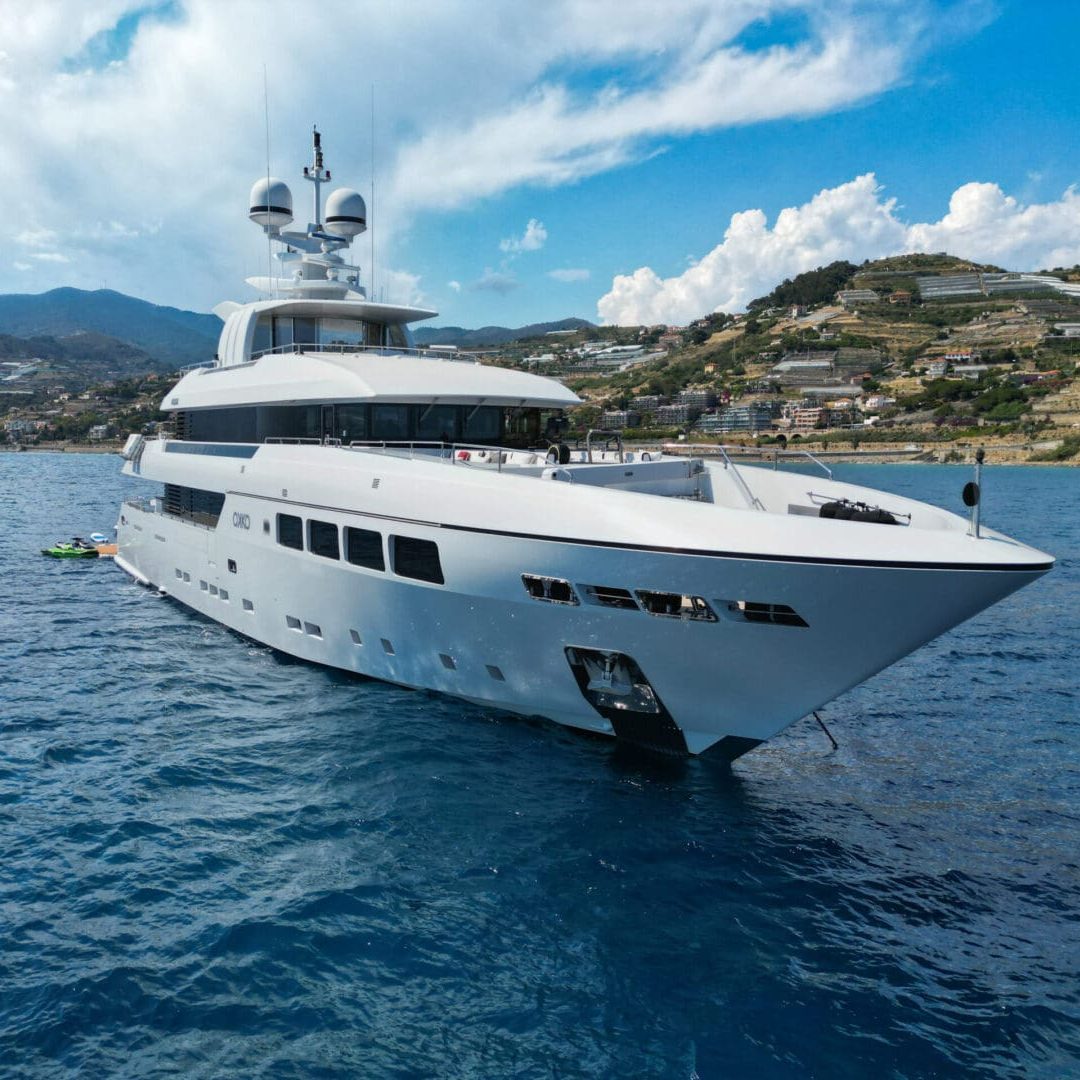 A large white yacht on a calm sea.