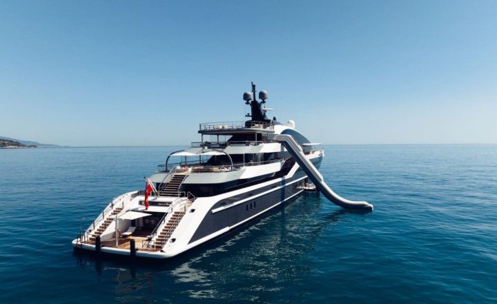 A large white and black yacht with a slide.