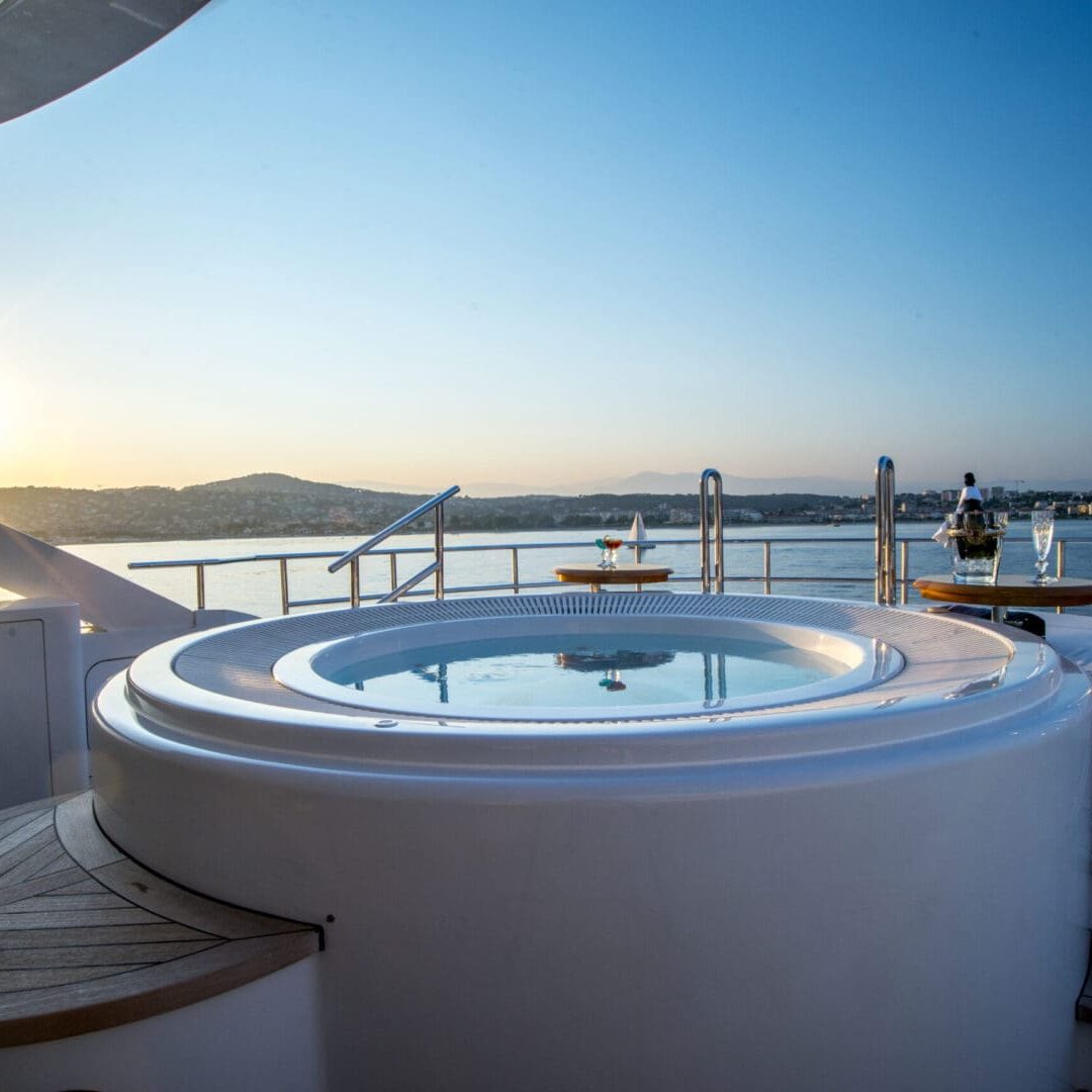 Hot tub on a yacht with sunset in the background.