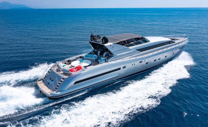 A silver yacht is cruising on the blue sea.