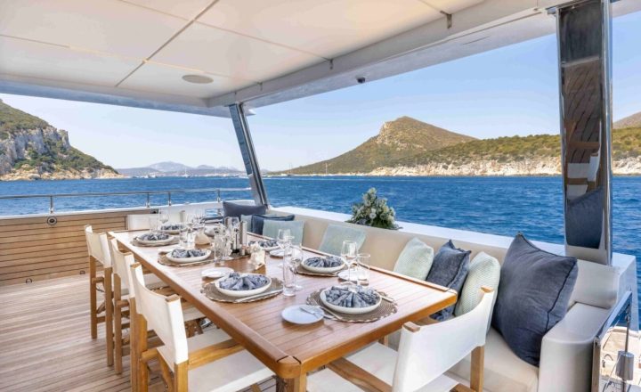 Yacht's dining table set for lunch with a sea view.