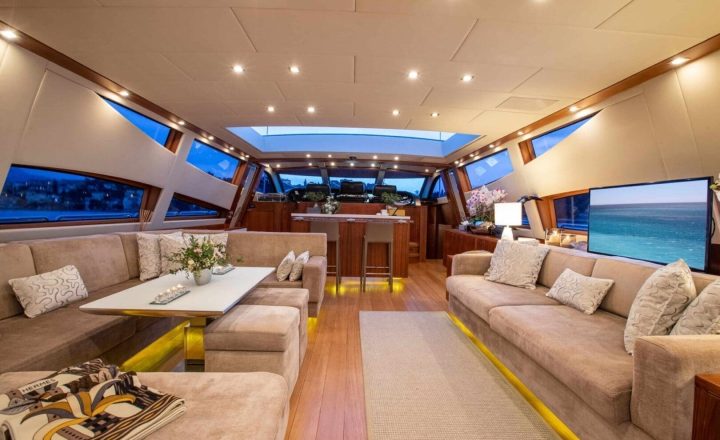 Interior of a luxury yacht with sofas and a bar.